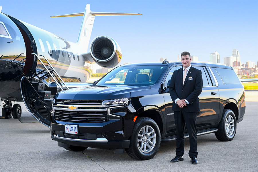 A Chevrolet Suburban with a PAX certified professional chauffeur, representing the premium transportation services offered by LEADER Worldwide Chauffeured Services for executive travel.