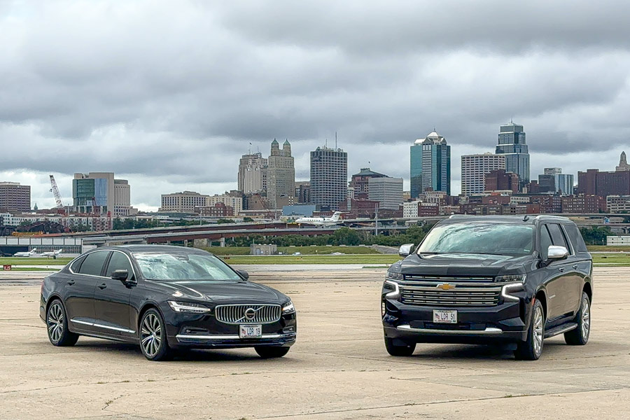 A Chevrolet Suburban parked next to a Volvo, showcasing the range of luxury vehicles available from LEADER Worldwide Chauffeured Services for comfortable travel options.